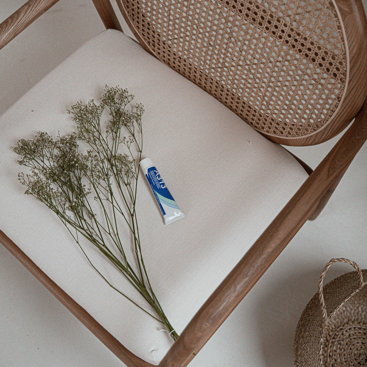 A313 retinol cream on a rattan chair with baby's breath