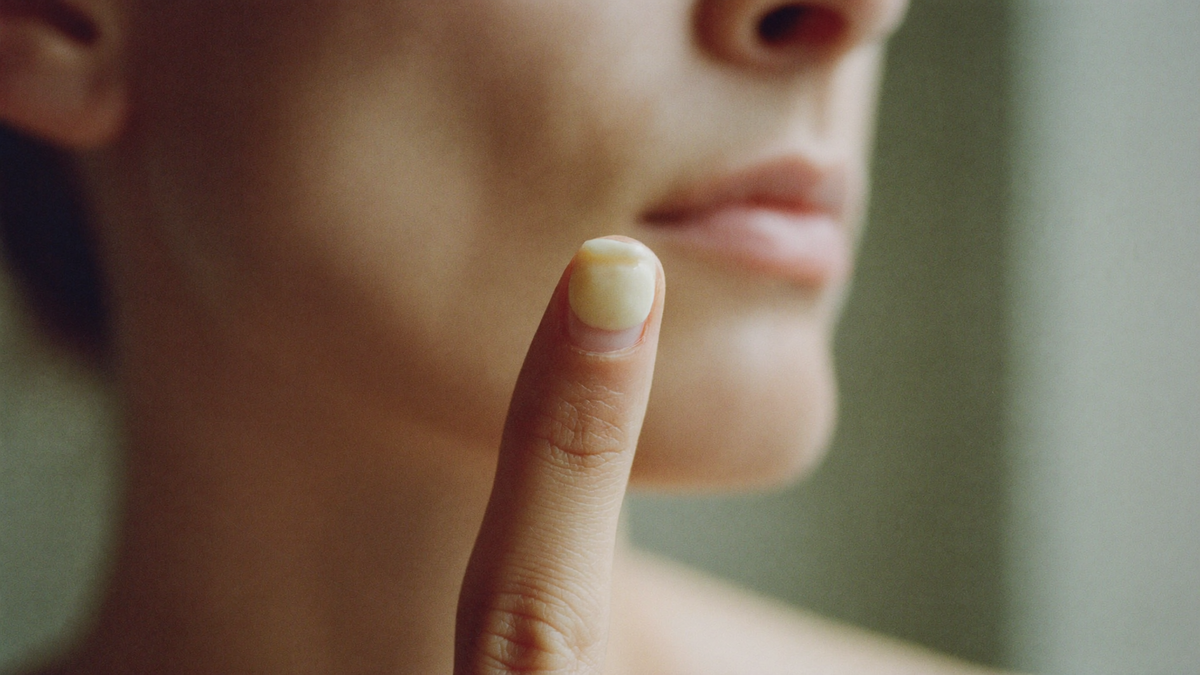 Eine erbsengroße Menge Creme auf einer Fingerspitze, die richtige Dosis für das ganze Gesicht