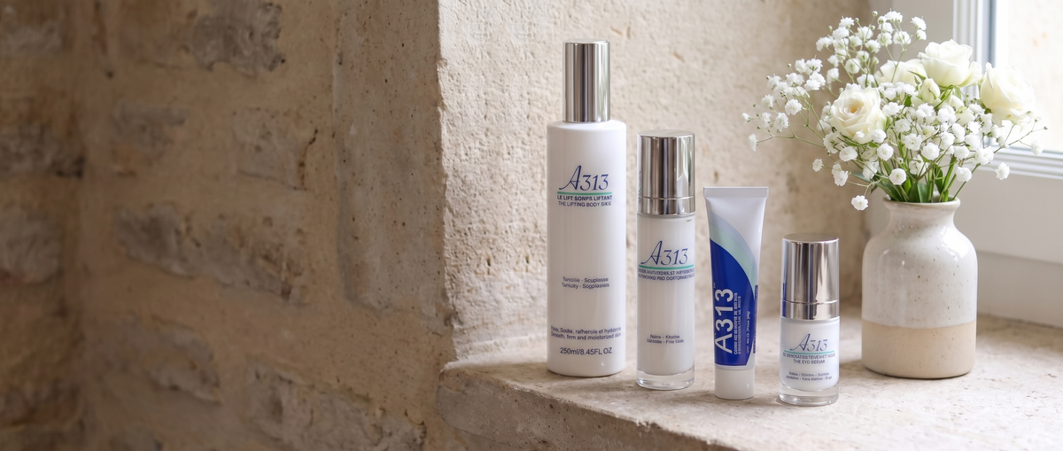 A313 skincare range on a stone windowsill with white roses